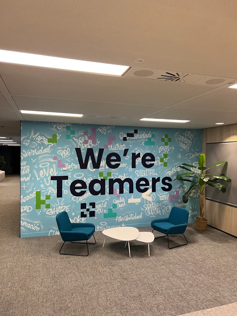 Grafiteros profesionales que han pintado un mural corporativo personalizado en la pared interior de una oficina para mejorar el branding.