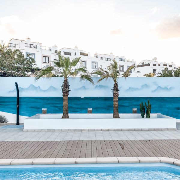 Mural decorativo en la pared de una piscina privada con un diseño de playa tropical pintado con materiales de alta calidad.