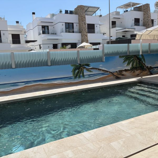Mural de pared para piscina privada con diseño de fondo marino hiperrealista, creando un efecto de profundidad y oasis tropical en el jardín.